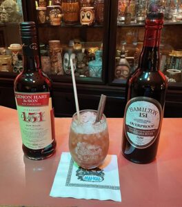 Version 7 of the 151 Swizzle tribute, served in a Mai-Kai glass and flanked by the two dominant overproof Demerara rums - Lemon Hart and Hamilton. (Photo by Hurricane Hayward, November 2021)