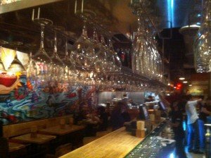 A view of the dining room and open kitchen from the side of the bar.