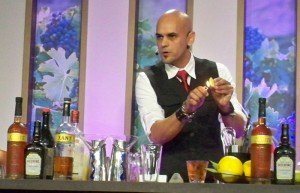 Mixologist Freddy Diaz demonstrates how to flame an orange peel to give a drink the essence of fruit