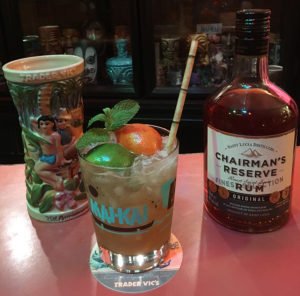 Oh Mai Darling featuring Chairman’s Reserve Original rum and served in The Hukilau glassware designed by Anna Powell and Tiki Kiliki featuring logo artwork by Kevin Kidney. Background: Trader Vic's 75th anniversary Fogcutter mug. (Photo by Hurricane Hayward, September 2018)